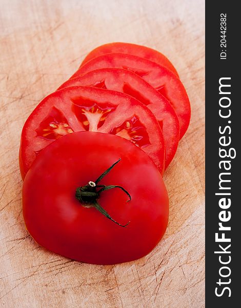Fresh red tomato slices on wooden board