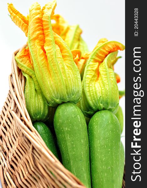 Zucchini with flowers in a basket on a white background. Zucchini with flowers in a basket on a white background