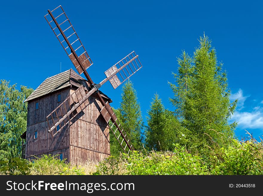 Old traditional wooden windmill hidden in forest.