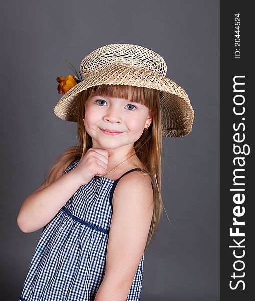 Little girl in a dress with a straw hat