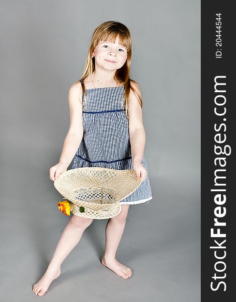 Little Girl In A Dress With A Straw Hat