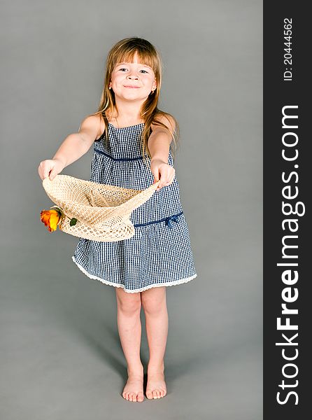 Little girl in a dress with a straw hat