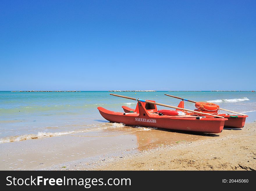 Orange red Rescue boat on the beach with sea and blue sky. Orange red Rescue boat on the beach with sea and blue sky