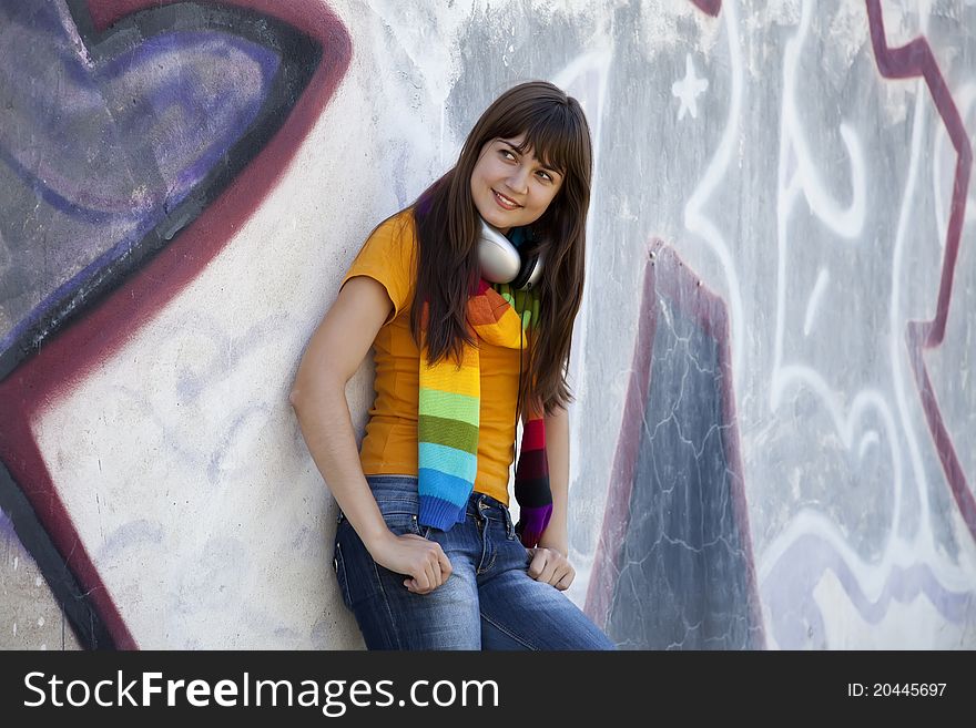 Teen Girl With Earphones Near Graffiti Wall.