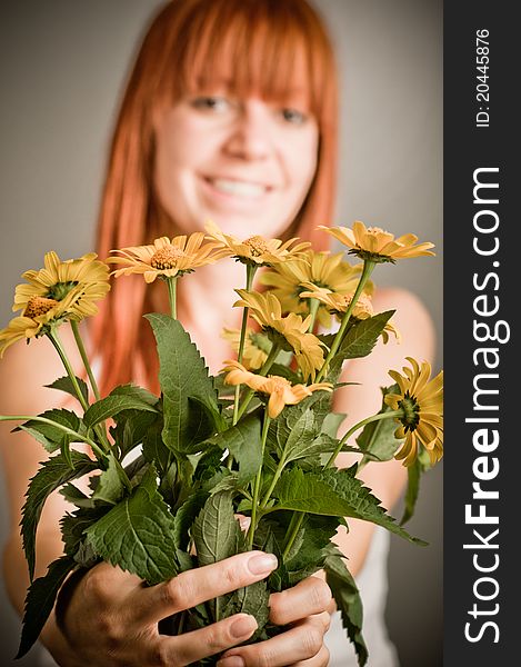 Beautiful young redhead girl with yellow flower