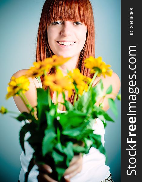 Beautiful young redhead girl with yellow flower