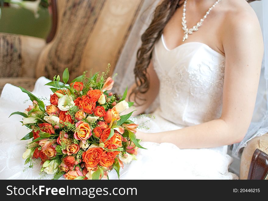 Bride holding bouquet of red and orange roses