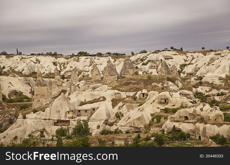 Panoramic view of Goreme, Cappadocia, Turkey under a layer of clouds. Landscape of rock formation and weathered limestone chimneys, copy space. Panoramic view of Goreme, Cappadocia, Turkey under a layer of clouds. Landscape of rock formation and weathered limestone chimneys, copy space