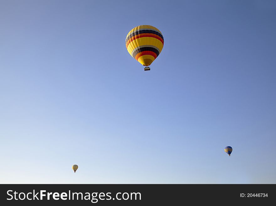 Three hot air balloons clear blue sky