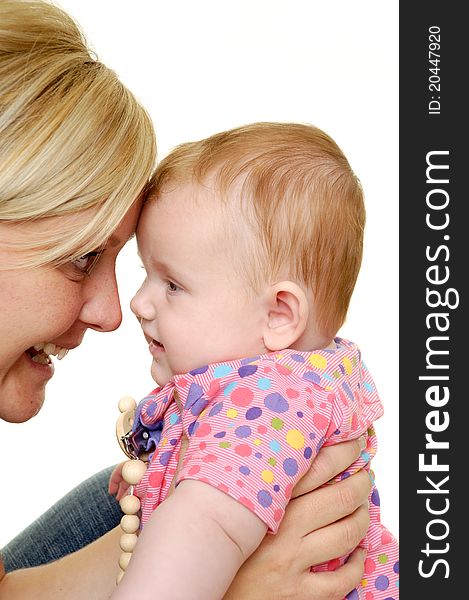 Mother is looking down on her sweet smiling baby. Taken on a white background. Mother is looking down on her sweet smiling baby. Taken on a white background.