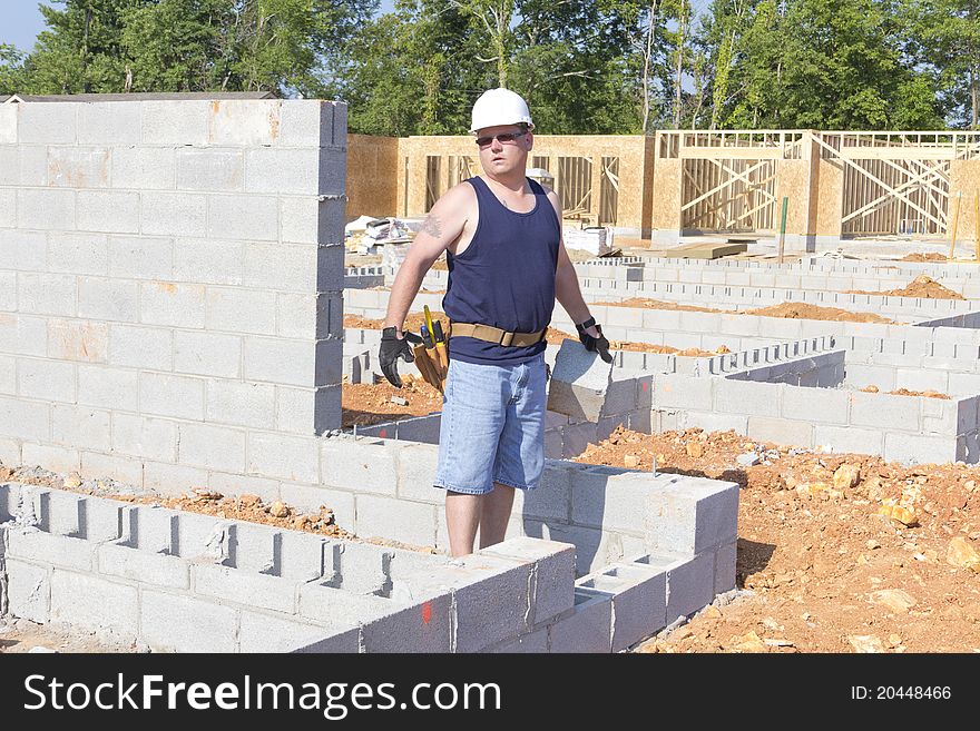 Mason removing cider block from foundation, getting ready to set next wall. Mason removing cider block from foundation, getting ready to set next wall