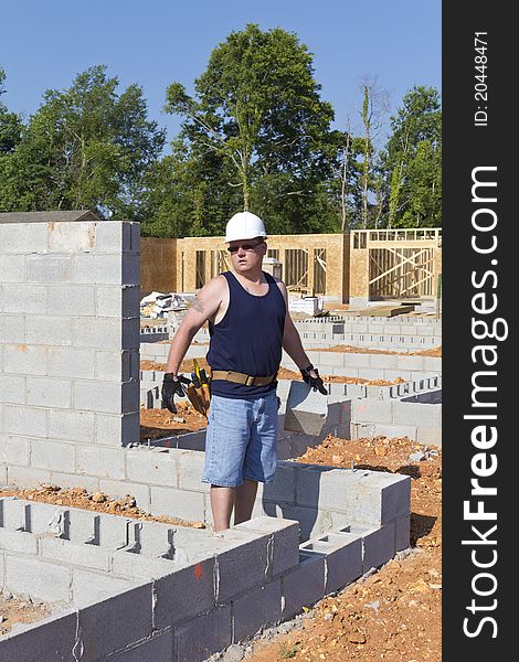 Mason removing cider block from foundation, getting ready to set next wall. Mason removing cider block from foundation, getting ready to set next wall