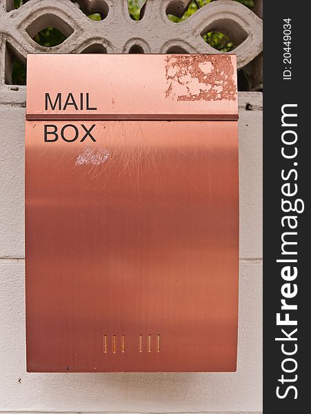 Orange brown metal mailbox on wall