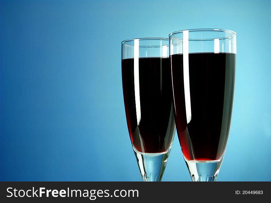 Two glasses of red wine on a blue background. Two glasses of red wine on a blue background