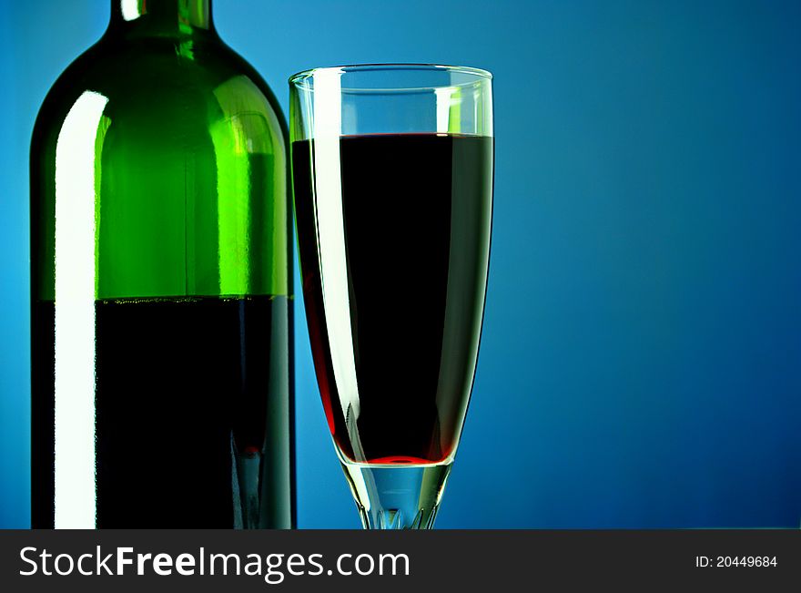 Wine bottle and glass on a blue background