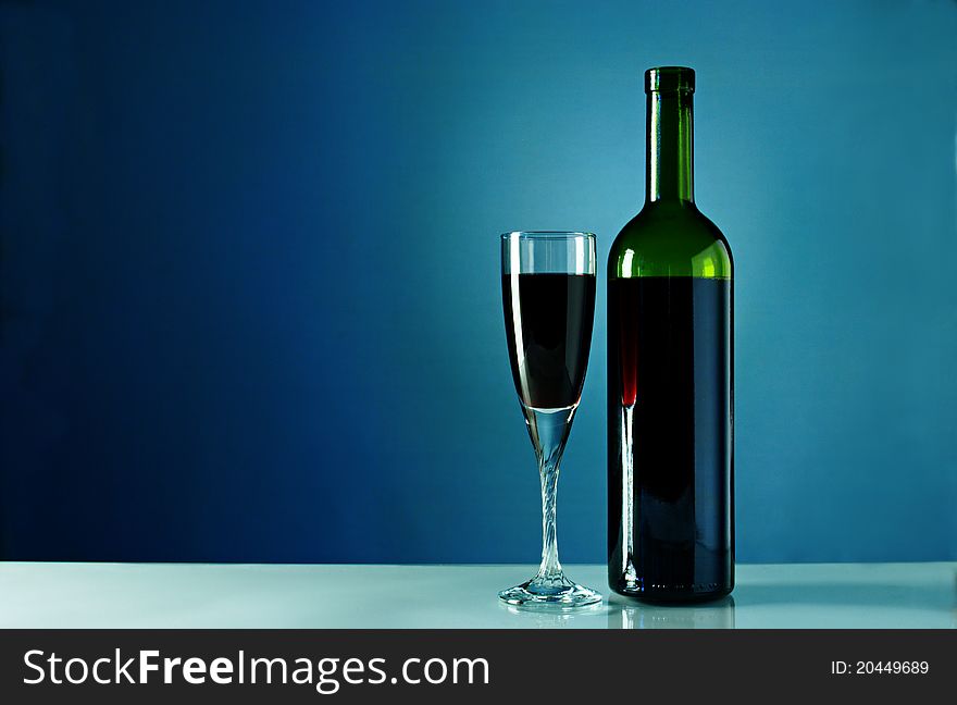 Wine Bottle And Glass On A Blue Background