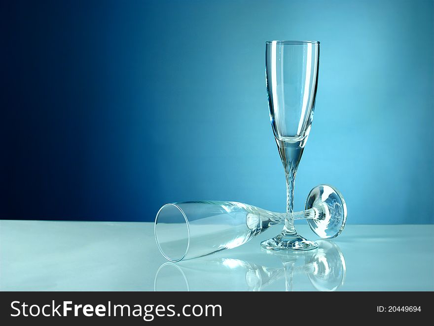 Two empty glasses on a blue background. Two empty glasses on a blue background