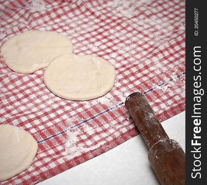 Dough and rolling pin on a checked tablecloth