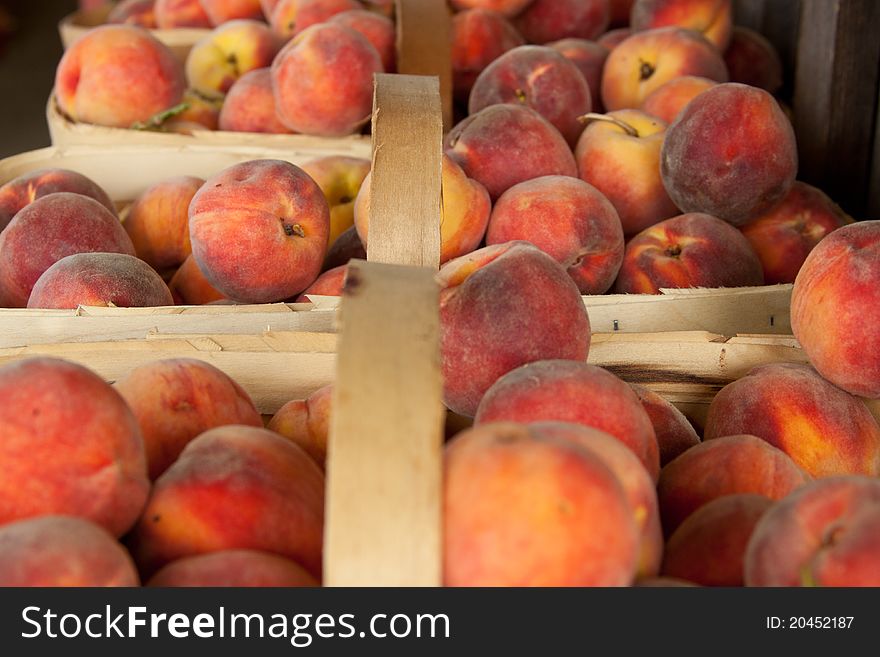 Baskets of fresh peaches at a farmer's produce stand.