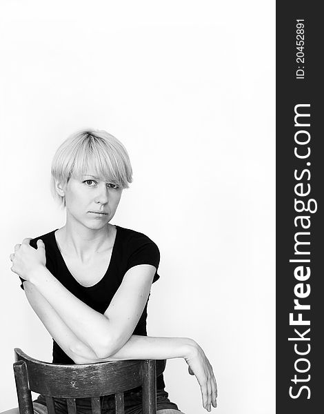 A young pretty woman sitting on a chair, for white background.