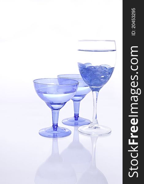 Blue wine Glasses with water and blue glass pebbles