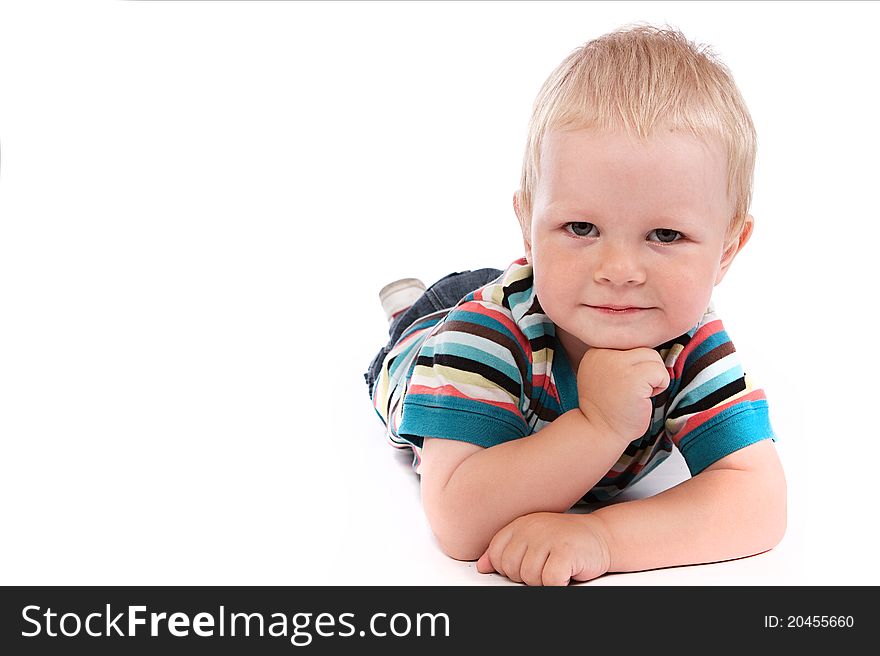 Portrait Of A Happy 2 Year Boy Lying On A Floor.