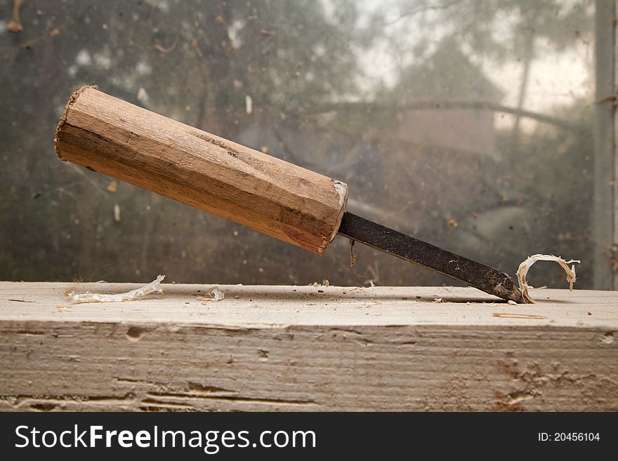 Hammer and nail on wood chunck on top of each other