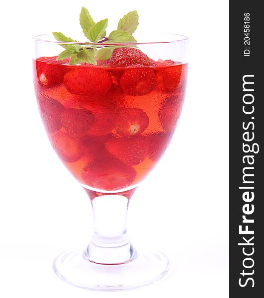 Jelly with strawberries decorated with a mint twig in a glass cup. Jelly with strawberries decorated with a mint twig in a glass cup