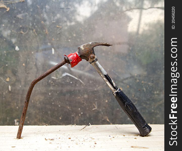 Hammer and nail on wood chunk on top of each other