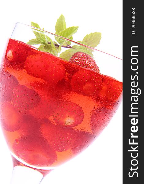 Jelly with strawberries decorated with a mint twig in a glass cup. Jelly with strawberries decorated with a mint twig in a glass cup