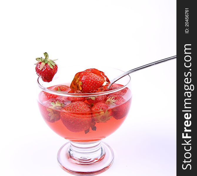 Jelly with strawberries being eaten with a spoon. Jelly with strawberries being eaten with a spoon