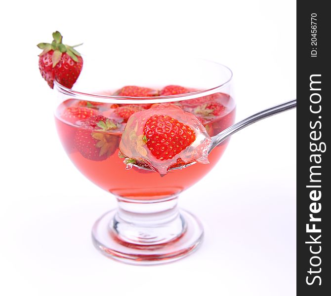 Jelly with strawberries being eaten with a spoon. Jelly with strawberries being eaten with a spoon