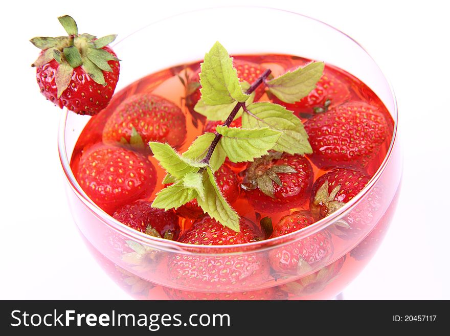 Jelly with strawberries decorated with a mint twig in a glass cup. Jelly with strawberries decorated with a mint twig in a glass cup