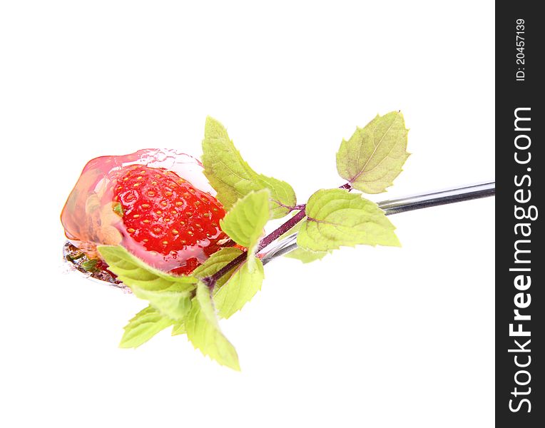 Jelly with a strawberry on a spoon decorated with mint on white background. Jelly with a strawberry on a spoon decorated with mint on white background