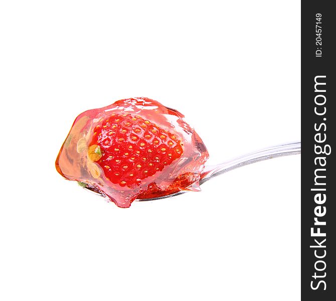 Jelly with a strawberry on a spoon on white background. Jelly with a strawberry on a spoon on white background