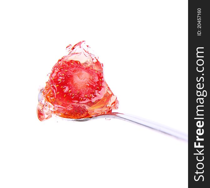 Jelly with a strawberry on a spoon on white background. Jelly with a strawberry on a spoon on white background