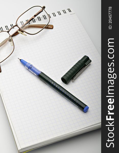 Notebook and pen on a light grey background