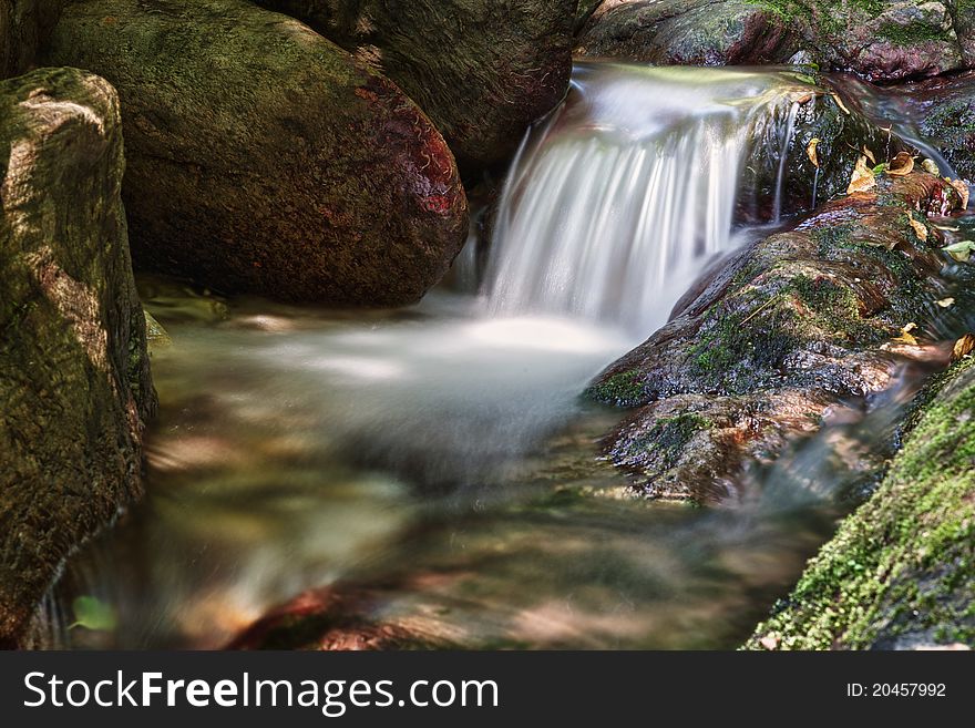 Beautiful cascading waterfall over natural rocks, landscaping