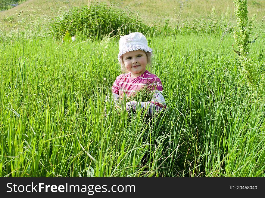 The girl walks on a meadow in a high green grass. The girl walks on a meadow in a high green grass