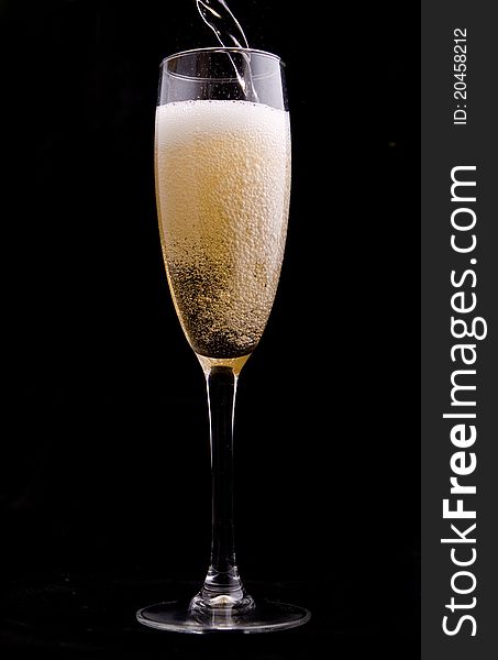 Wine being poured into a glass on black background