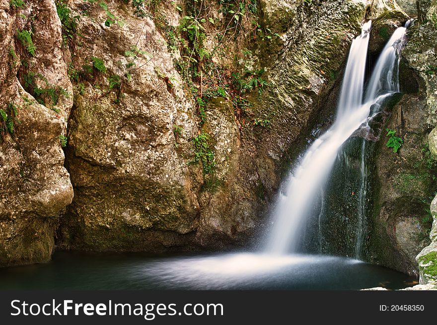 Beautiful cascading waterfall over natural rocks, landscaping