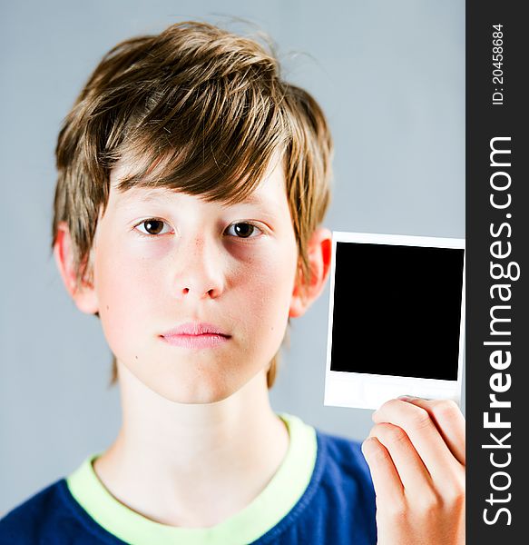 A teenager holding a blank polaroid photograph. A teenager holding a blank polaroid photograph