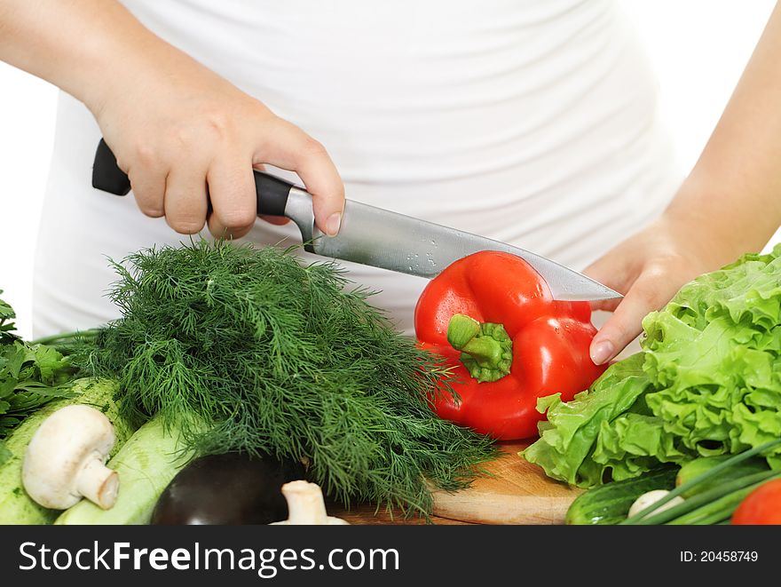 Woman's hands cutting vegetablesat the kitchen