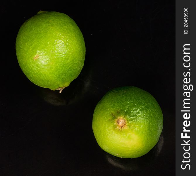 Two limes on a black background