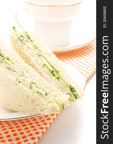 English sandwiches. Stuffing a cucumber, dill and butter. The shape is triangular. In the background is visible with a cup of tea. English sandwiches. Stuffing a cucumber, dill and butter. The shape is triangular. In the background is visible with a cup of tea.