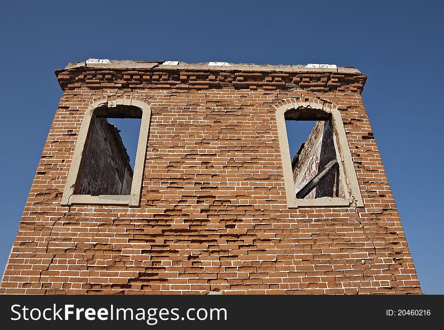 Ruins of a tower with brick walls against a blue clear sky. Ruins of a tower with brick walls against a blue clear sky