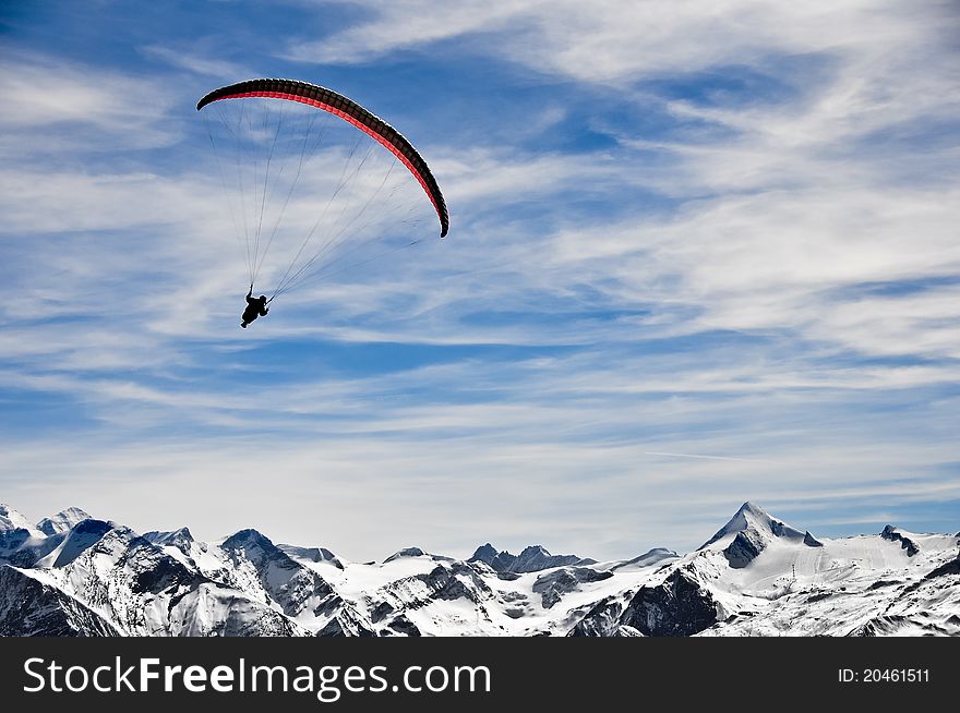 Man flying on red and yellow parachute in the mountains. Man flying on red and yellow parachute in the mountains