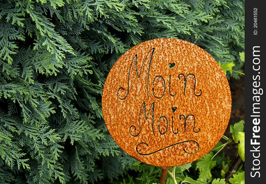 Happy welcome in northern german dialect in front of a hedge