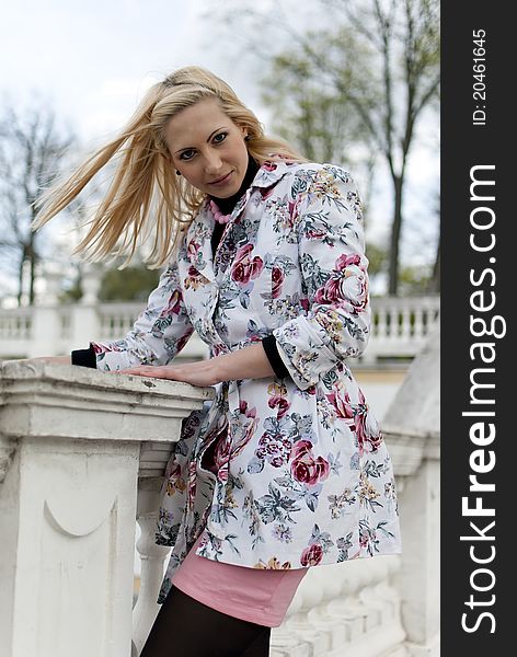 Blonde girl is leaning on old railing against the park. Blonde girl is leaning on old railing against the park