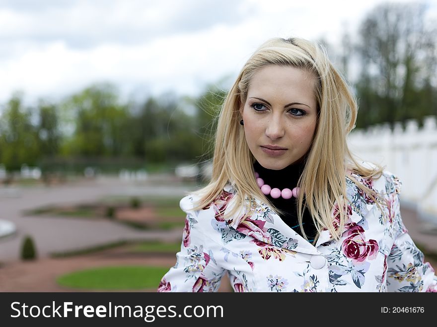 Blonde girl on the background of the park, portrait